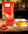 Niederegger Marzipan-Rooibos-Tee: rote Packung und Tasse mit orangefarbenem Tee